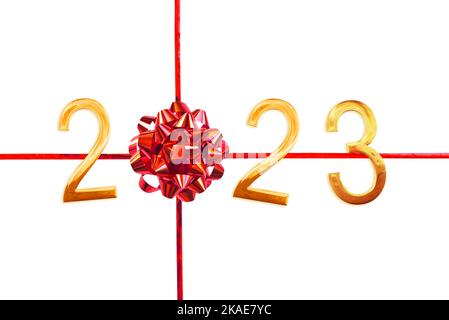 2023 numeri dorati, arco regalo rosso e nastro isolato su sfondo bianco, biglietto di auguri per il nuovo anno Foto Stock