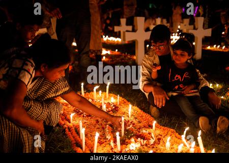 Dhaka, Bangladesh. 2nd Nov 2022. I cristiani cattolici di tutto il mondo osservano la Giornata dell'anima intera che celebra una giornata di preghiere per la pace dei morti, il secondo giorno di novembre di ogni anno. I devoti cristiani hanno messo ghirlande e candele accese nel cimitero dopo le preghiere della sera nella chiesa del Santo Rosario, Tejgaon a Dhaka, Bangladesh. (Credit Image: © Md. Rakibul Hasan/ZUMA Press Wire) Credit: ZUMA Press, Inc./Alamy Live News Foto Stock