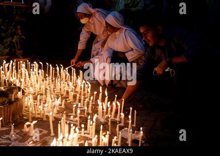 Dhaka, Bangladesh. 2nd Nov 2022. I cristiani cattolici di tutto il mondo osservano la Giornata dell'anima intera che celebra una giornata di preghiere per la pace dei morti, il secondo giorno di novembre di ogni anno. I devoti cristiani hanno messo ghirlande e candele accese nel cimitero dopo le preghiere della sera nella chiesa del Santo Rosario, Tejgaon a Dhaka, Bangladesh. (Credit Image: © Md. Rakibul Hasan/ZUMA Press Wire) Credit: ZUMA Press, Inc./Alamy Live News Foto Stock