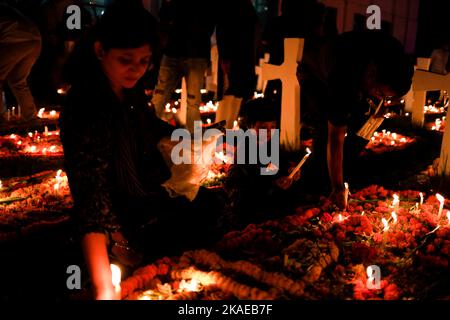 Dhaka, Bangladesh. 2nd Nov 2022. I cristiani cattolici di tutto il mondo osservano la Giornata dell'anima intera che celebra una giornata di preghiere per la pace dei morti, il secondo giorno di novembre di ogni anno. I devoti cristiani hanno messo ghirlande e candele accese nel cimitero dopo le preghiere della sera nella chiesa del Santo Rosario, Tejgaon a Dhaka, Bangladesh. (Credit Image: © Md. Rakibul Hasan/ZUMA Press Wire) Credit: ZUMA Press, Inc./Alamy Live News Foto Stock