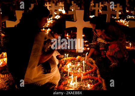 Dhaka, Bangladesh. 2nd Nov 2022. I cristiani cattolici di tutto il mondo osservano la Giornata dell'anima intera che celebra una giornata di preghiere per la pace dei morti, il secondo giorno di novembre di ogni anno. I devoti cristiani hanno messo ghirlande e candele accese nel cimitero dopo le preghiere della sera nella chiesa del Santo Rosario, Tejgaon a Dhaka, Bangladesh. (Credit Image: © Md. Rakibul Hasan/ZUMA Press Wire) Credit: ZUMA Press, Inc./Alamy Live News Foto Stock