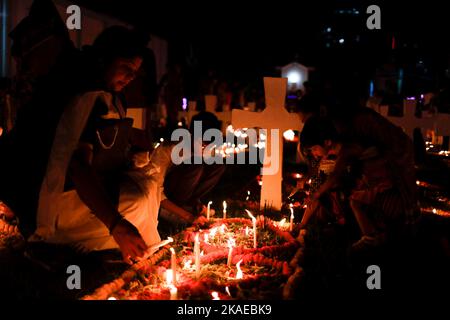 Dhaka, Bangladesh. 2nd Nov 2022. I cristiani cattolici di tutto il mondo osservano la Giornata dell'anima intera che celebra una giornata di preghiere per la pace dei morti, il secondo giorno di novembre di ogni anno. I devoti cristiani hanno messo ghirlande e candele accese nel cimitero dopo le preghiere della sera nella chiesa del Santo Rosario, Tejgaon a Dhaka, Bangladesh. (Credit Image: © Md. Rakibul Hasan/ZUMA Press Wire) Credit: ZUMA Press, Inc./Alamy Live News Foto Stock