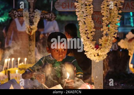 Kolkata, India. 02nd Nov 2022. Un ragazzo accende le candele davanti alla tomba del suo membro della famiglia in occasione della giornata di tutte le anime. Tutta la giornata delle anime è celebrata dai cristiani che rendono omaggio ai loro amici e parenti, che sono passati. Le tombe sono decorate splendidamente con fiori, candele e bastoni di incenso. Credit: SOPA Images Limited/Alamy Live News Foto Stock