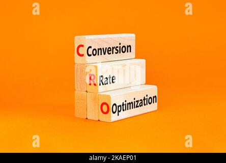 Simbolo di ottimizzazione del tasso di conversione CRO. Concetto di parole CRO tasso di conversione ottimizzazione su blocchi di legno su uno sfondo arancione bello. Business CR Foto Stock