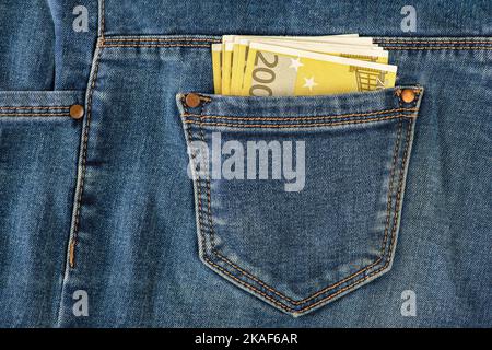 Una pila di banconote da 200 euro in una tasca di jeans. Soldi nella tasca posteriore dei miei jeans. Il concetto di investimento, denaro, ricchezza e profitto. copyspace. Foto Stock