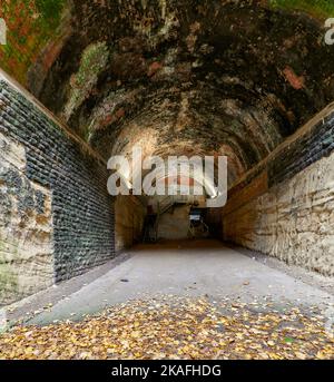 Tunnel del Parco superiore con volta in mattoni e parete in parte rivestita in pietra, in parte roccia non rivestita, guardando verso l'uscita superiore parzialmente chiusa Foto Stock