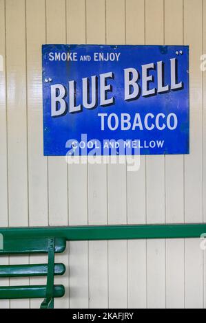 Vintage Enamel pubblicità segno sulla parete della stazione East Grinstead sulla linea ferroviaria Bluebell, Sussex orientale, Inghilterra. Foto Stock