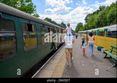 Vecchio e nuovo: Treno della Ferrovia Meridionale che condivide una piattaforma con un treno a vapore della Ferrovia Bluebell vintage alla stazione di East Grinstead, Sussex Orientale, Inghilterra. Foto Stock