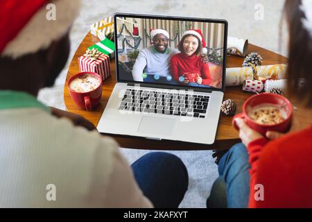 Coppia diversa che ha videochiamata di natale con coppia diversa Foto Stock