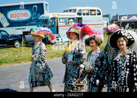 Quattro donne che indossano giacche e camicie con bottoni di diverse dimensioni cuciti su di loro frequentando English Derby, Epsom Downs Racecourse, Epsom, Surrey, Inghilterra, UK, toni Frissell Collection, 3 giugno 1959 Foto Stock