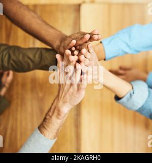 L'abbiamo fatto. Ripresa ad angolo alto di un gruppo di studenti universitari irriconoscibili che si sono accaniti mentre studiano in biblioteca. Foto Stock