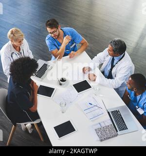 Scendendo alla gritty nitty della medicina. Inquadratura ad angolo alto di una squadra di medici che si riunisce in un ospedale. Foto Stock