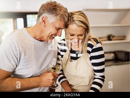 Il nostro amore è qualcosa che la gente fa film circa. Una coppia matura felice che tiene l'altra azienda nella cucina. Foto Stock