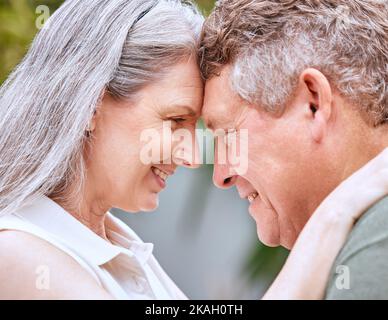 Amore abbraccio, fronte e coppia senior legame, sorriso o felice in vacanza anniversario per la pace, fiducia o partnership. Romantico contatto visivo, matrimonio e. Foto Stock