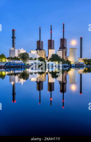 Una centrale elettrica a Berlino durante l'ora blu riflessa in un canale Foto Stock