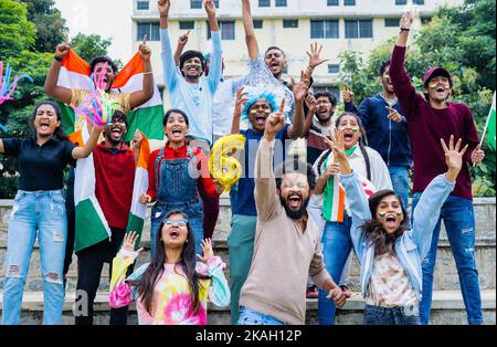 il pubblico entusiasta festeggia i sixer urlando e urlando mostrando gesti e segni delle mani mentre si guarda la partita di cricket allo stadio - concetto di Foto Stock