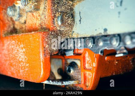 Catena della motosega sul primo piano dello pneumatico. Denti di sega per il taglio del legno su uno sfondo sfocato. Attrezzo agricolo Foto Stock