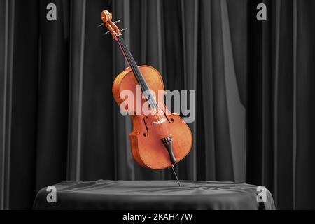 Bel violoncello in legno su tavolo ricoperto di tessuto satinato nero su sfondo di tenda nera. Invito a concerti o lezioni di violoncello. rendering 3d Foto Stock