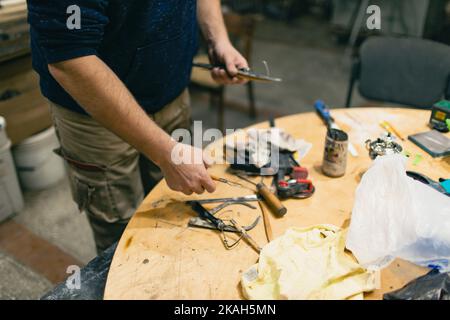 Uomo scultore crea scultura donna uomo in argilla sculpta. Laboratorio di creazione di statue artigianali. Piccola impresa. Foto Stock