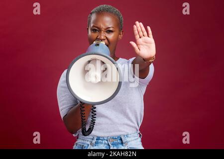 Donna nera, protesta e urla con il megafono per voce, sciopero o fermare contro uno studio di background. Ritratto di attivista femminile africana con mano Foto Stock