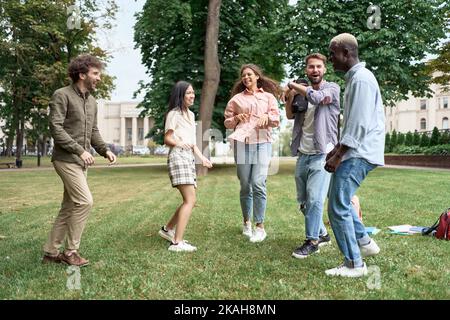 gruppo di giovani che ballano nel parco in erba . Foto Stock