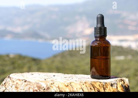 Bottiglia di olio cosmetico naturale per la cura del corpo e della pelle, aromaterapia su uno sfondo di legno. Estratto di oli naturali, concetto di prodotti medici. Foto di alta qualità Foto Stock