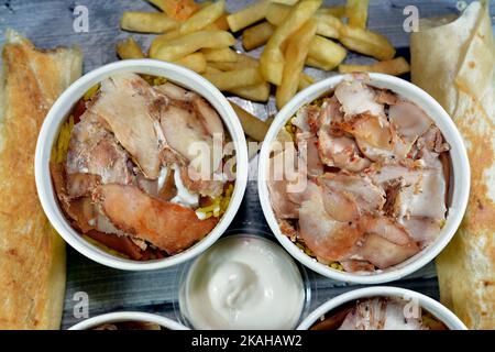 Pezzi di pollo shawarma e riso basmati giallo, pane siriano e salsa all'aglio, fattah Shawerma o fateh, sandwich di tortilla Shawarma wrap, frenc Foto Stock