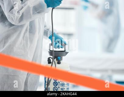 Pulizia, disinfezione e persona in tuta di nocciola in laboratorio con igienizzatore per pulire germi, esposizione ai virus e spray. Covid, igiene e operatore medico Foto Stock