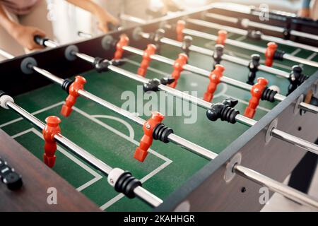 Football, gioco e divertimento con le persone che giocano un gioco all'interno di una clubhouse o a una festa insieme. Calcio, tavolo e competizione con amici che si legano Foto Stock