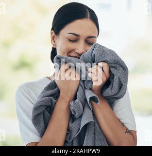 Bucato pulito, donna felice e asciugamano odore, profumo e tessuto fresco, lavaggio e biancheria tessile a casa. Giovane persona sorridente, servizio di pulizia e Foto Stock