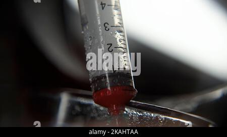 Siringa da cui viene prelevato il sangue, prelievo di campioni di sangue medico, diagnosi di malattie, concetto di sangue medico Foto Stock