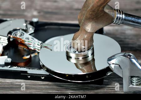 Chiave a bussola e martello in acciaio con dischi HDD, disco rigido smontato componenti danneggiati, manutenzione computer, ripristino, cancellazione dati, dati k Foto Stock