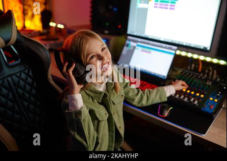 Giovane ingegnere audio che mixa il suono in casa di produzione Foto Stock