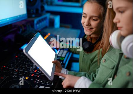 Ragazze giovani che regolano il suono sul mixer nella stazione radio Foto Stock