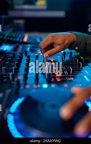 Primo piano mano maschio sulla console del mixer audio Foto Stock