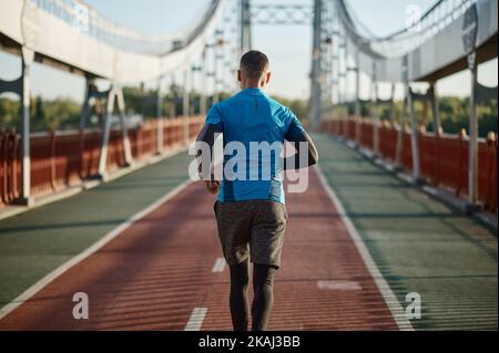 Allenamento dei corridori jogging sulla strada all'esterno nella vista posteriore Foto Stock