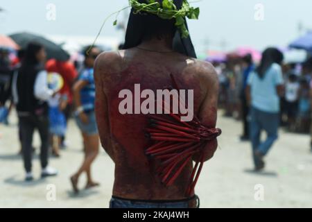 PROVINCIA DI PAMPANGA, Filippine - Un penitente filippino si frusta sulle spalle durante i riti quaresimale nella città di San Fernando, provincia di Pampanga il Venerdì Santo, 25 marzo 2016. L'autoflagellazione è uno dei tanti atti di penitenza compiuti dai cattolici filippini nella speranza di perdono dei loro peccati mentre celebrano il tempo quaresimale. (Foto di George Calvelo/NurPhoto) *** Please use Credit from Credit Field *** Foto Stock