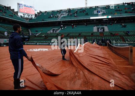 Gli operai coprono il tarp durante la partita del quarto turno maschile tra Novak Djokovic di Serbia e Roberto Bautista Augt di Spainon, dieci giorni del 2016° Open francese al Roland Garros il 31 maggio 2016 a Parigi, Francia. (Foto di Mehdi Taamallah/NurPhoto) *** Please use Credit from Credit Field *** Foto Stock