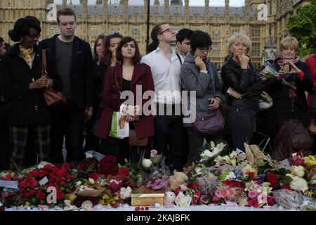 La gente si trova di fronte a un consiglio di amministrazione che porta messaggi in ricordo del deputato laburista ucciso Jo Cox in Piazza del Parlamento di fronte alle Camere del Parlamento nel centro di Londra il 18 giugno 2016. Il presunto assassino del legislatore britannico Jo Cox si è arrangiato contro i traditori durante una breve apparizione in tribunale sabato, mentre la campagna referendaria dell'UE è stata sospesa per un terzo giorno in omaggio al deputato ucciso. Il deputato di 41 anni è stato ucciso e pugnalato per strada in quella che la polizia ha chiamato un attacco di luce naturale 'mirato' il 16 giugno nella sua circoscrizione nel nord dell'Inghilterra, mentre stava arrivando per un incontro con i residenti locali. (PH Foto Stock