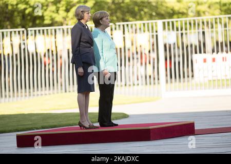 Il cancelliere tedesco Angela Merkel e il primo ministro britannico Theresa possono ascoltare gli inni nazionali alla Cancelleria di Berlino, in Germania, il 20 luglio 2016. Foto Stock