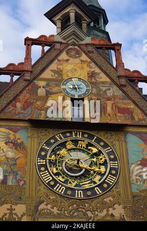 Una bella vista sulla torre dell'orologio del Municipio di Ulm in Germania con simboli araldici e murales sulla parete Foto Stock