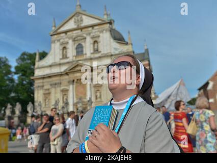 Suor Renata, polacca, tiene una croce e la Bibbia mentre si esibisce davanti alla Chiesa di San Pietro e Paolo di Cracovia. Pellegrini provenienti da tutto il mondo alla vigilia della Giornata Mondiale della Gioventù 2016 partecipano a concerti ed eventi nel quadro del Festival della Misericordia nel centro di Cracovia. La GMG è anche l'occasione per tutte le religiose, i fratelli e i sacerdoti di tutto il mondo di incontrarsi con Papa Francesco. Domenica 24 luglio 2016, a Cracovia, Polonia. Foto di Artur Widak *** Please use Credit from Credit Field *** Foto Stock