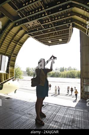 Una ragazza scatta una foto di un secondo modello dell'aereo da carico Antonov AN-225 'Mriyaa' presso lo stabilimento di aerei Antonov a Kiev, 7 settembre 2016. La leadership del produttore di aeromobili ucraino ha informato che il secondo caso di Antonov-225 'Mriyaa' (Dream), originariamente sviluppato per il programma di navetta spaziale abbandonata dell'Unione Sovietica, sarà finito per essere costruito per la Cina entro i prossimi cinque anni. L'impresa statale dell'Ucraina Antonov e l'Aerospace Industry Corporation of China (AICC) hanno firmato il 30 agosto un accordo per completare il secondo esempio mondiale dell'aeromobile AN-225 e lanciare il Large-sca Foto Stock