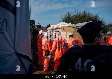 Le squadre francesi di demolizione smantellano a mano il famoso campo 'giungla' prima che le autorità demoliscano il sito il 25 ottobre 2016 a Calais, in Francia. La demolizione del campo migrante della giungla di Calais dovrebbe continuare dopo gli sfratti negli ultimi due giorni. Gli autobus rimuovono 3.000 persone nei centri di alloggio in tutta la Francia. Gli enti di beneficenza hanno sollevato una sfida legale, sostenendo che la demolizione è illegale fino a quando non è stato fornito un alloggio alternativo sufficiente per un massimo di 10.000 migranti che si stima vivano lì, tra cui 1.200 bambini. (Foto di Guillaume Pinon/NurPhoto) *** Pl Foto Stock