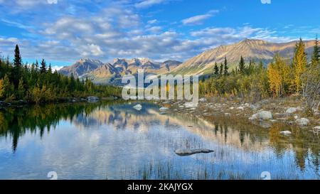 Un riflesso simmetrico girato sul lago in Wrangell, St.Elias National Park, Alaska, cime di montagna sullo sfondo, e cielo blu sopra Foto Stock