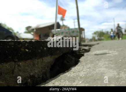 I residenti che passano il tratto di strada danneggiato con un veicolo dopo un forte terremoto il Mercoledì mattina qui a Pidie Jaya, provincia di Aceh, Indonesia, 10 dicembre 2016. Dasril Roszandi (Foto di Dasril Roszandi/NurPhoto) *** Please use Credit from Credit Field *** Foto Stock