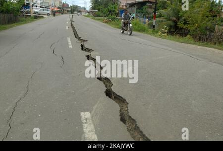 I residenti che passano il tratto di strada danneggiato con un veicolo dopo un forte terremoto il Mercoledì mattina qui a Pidie Jaya, provincia di Aceh, Indonesia, 10 dicembre 2016. Dasril Roszandi (Foto di Dasril Roszandi/NurPhoto) *** Please use Credit from Credit Field *** Foto Stock