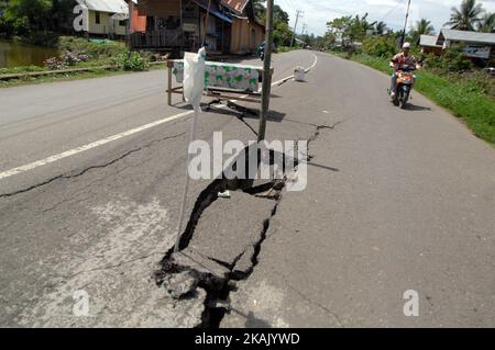 I residenti che passano il tratto di strada danneggiato con un veicolo dopo un forte terremoto il Mercoledì mattina qui a Pidie Jaya, provincia di Aceh, Indonesia, 10 dicembre 2016. (Foto di Dasril Roszandi/NurPhoto) *** Please use Credit from Credit Field *** Foto Stock