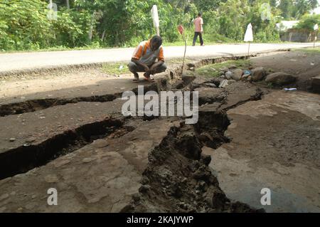 I residenti che passano il tratto di strada danneggiato con un veicolo dopo un forte terremoto il Mercoledì mattina qui a Pidie Jaya, provincia di Aceh, Indonesia, 10 dicembre 2016. Dasril Roszandi (Foto di Dasril Roszandi/NurPhoto) *** Please use Credit from Credit Field *** Foto Stock