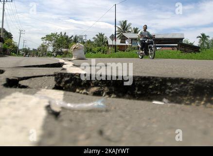 I residenti che passano il tratto di strada danneggiato con un veicolo dopo un forte terremoto il Mercoledì mattina qui a Pidie Jaya, provincia di Aceh, Indonesia, 10 dicembre 2016. Dasril Roszandi (Foto di Dasril Roszandi/NurPhoto) *** Please use Credit from Credit Field *** Foto Stock